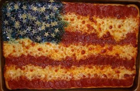 A pizza that is colored and topped to look like an American flag.