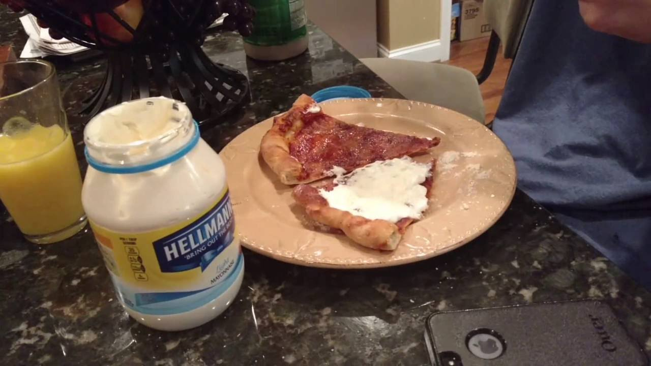 A pizza with a large dollop of mayo on it.