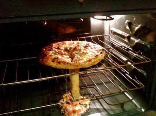 A pizza on a rack that has fallen through the gap in the cooking rack and forms the shape of a mushroom cloud.